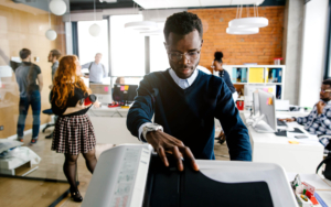 Person in office standing at printer