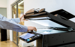 Side close up view of a person using scanner on printer