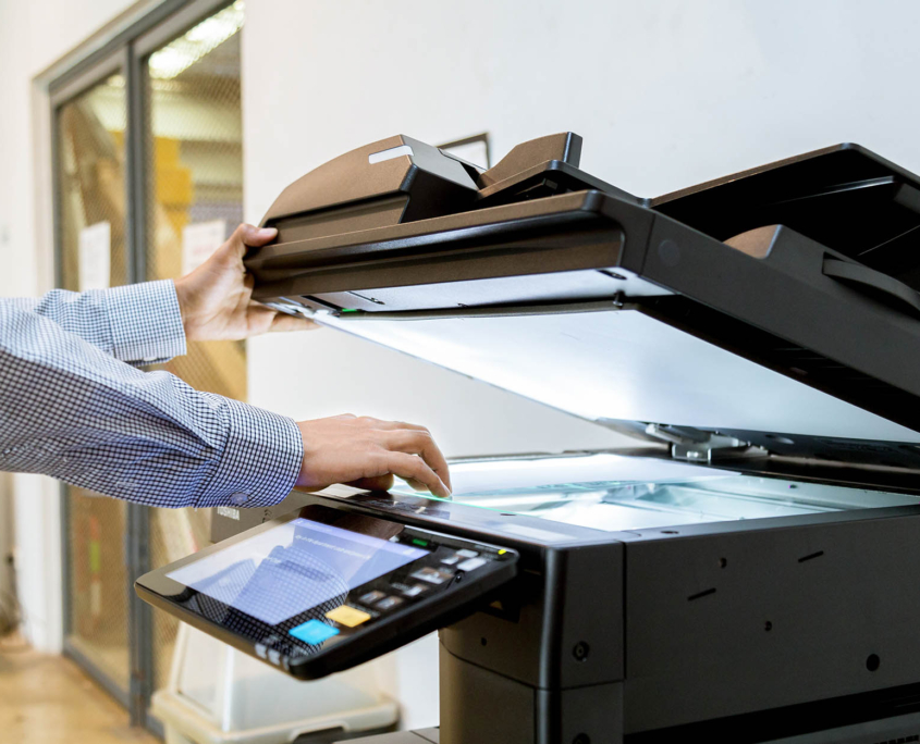 Side close up view of a person using scanner on printer