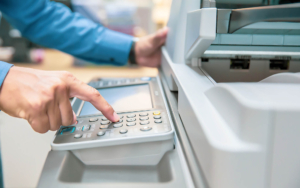 Side close up view of person pushing buttons on printer