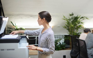 Side view of a person using the scanner on a multi function printer