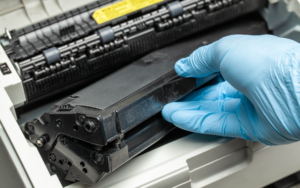 Close up view of person changing out toner in printer