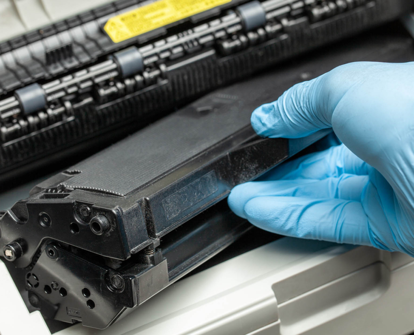 Close up view of person changing out toner in printer