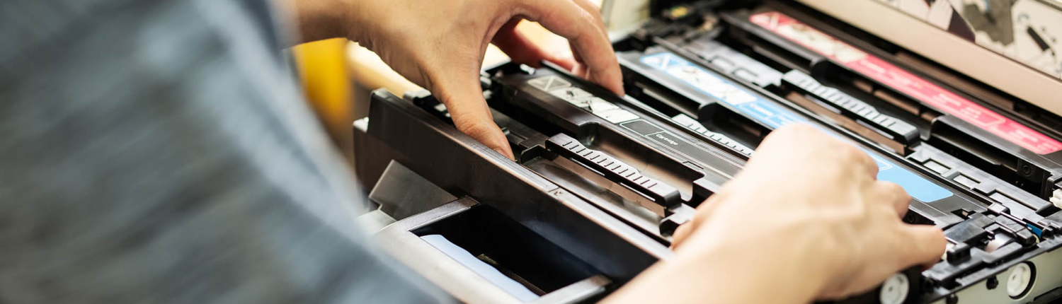 Overhead view of a person changing the toner in a printer