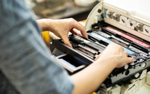 Overhead view of a person changing the toner in a printer