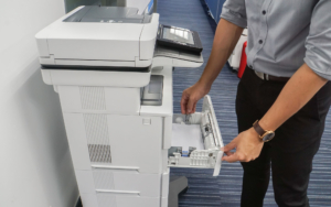 Person adding more paper to a print tray