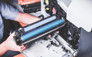 Person pulling out blue toner cartridge