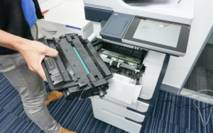 Person pulling out toner cartridge from printer