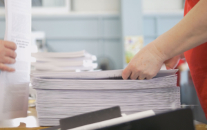 Person stacking newly printed pages