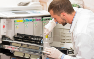 Side view of a person doing maintenance on a printer