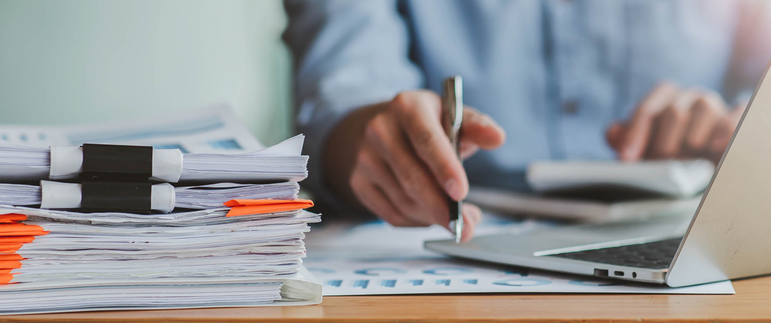 View of a person looking at computer with documents