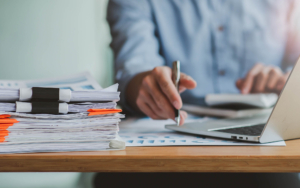 View of a person looking at computer with documents