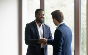 View of two people shaking hands in office