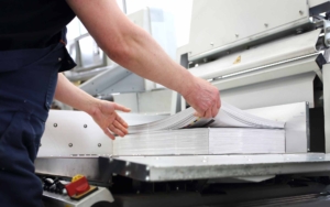 Paper trimming on a guillotine. Printing house. Cutter for cutting paper_