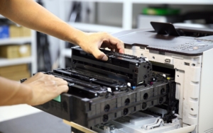 Close up view of person changing out toner in printer