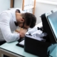 Image of a frustrated person trying to fix a printer.