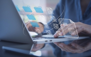 Image of a person using document management system on a laptop.