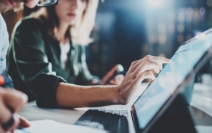 Image of two business people looking at documents on a tablet.