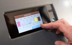 A person checking the ink levels on a printer.