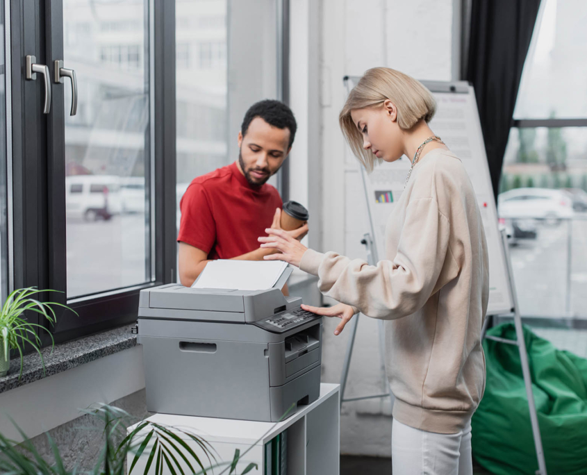 Two workers standing at an office printer