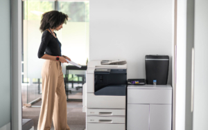 Worker standing next to printer waiting for documents
