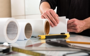 Close-up of a print specialist rolling up large bolts of paper