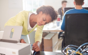 Front view of a young woman installing a printer