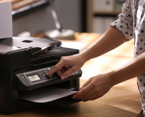 Side view of a woman operating a printer