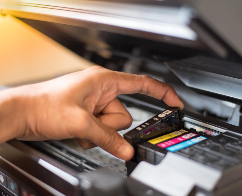 Side view of ink cartridges being replaced in a printer