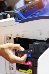 Side view of someone changing out ink cartridges on a printer