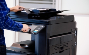 Side view of someone operating a commercial printer