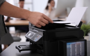 Side view of someone restocking a printer paper tray