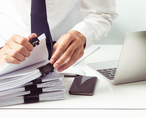 Front view of a sharply dressed person sorting through documents