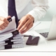 Front view of a sharply dressed person sorting through documents